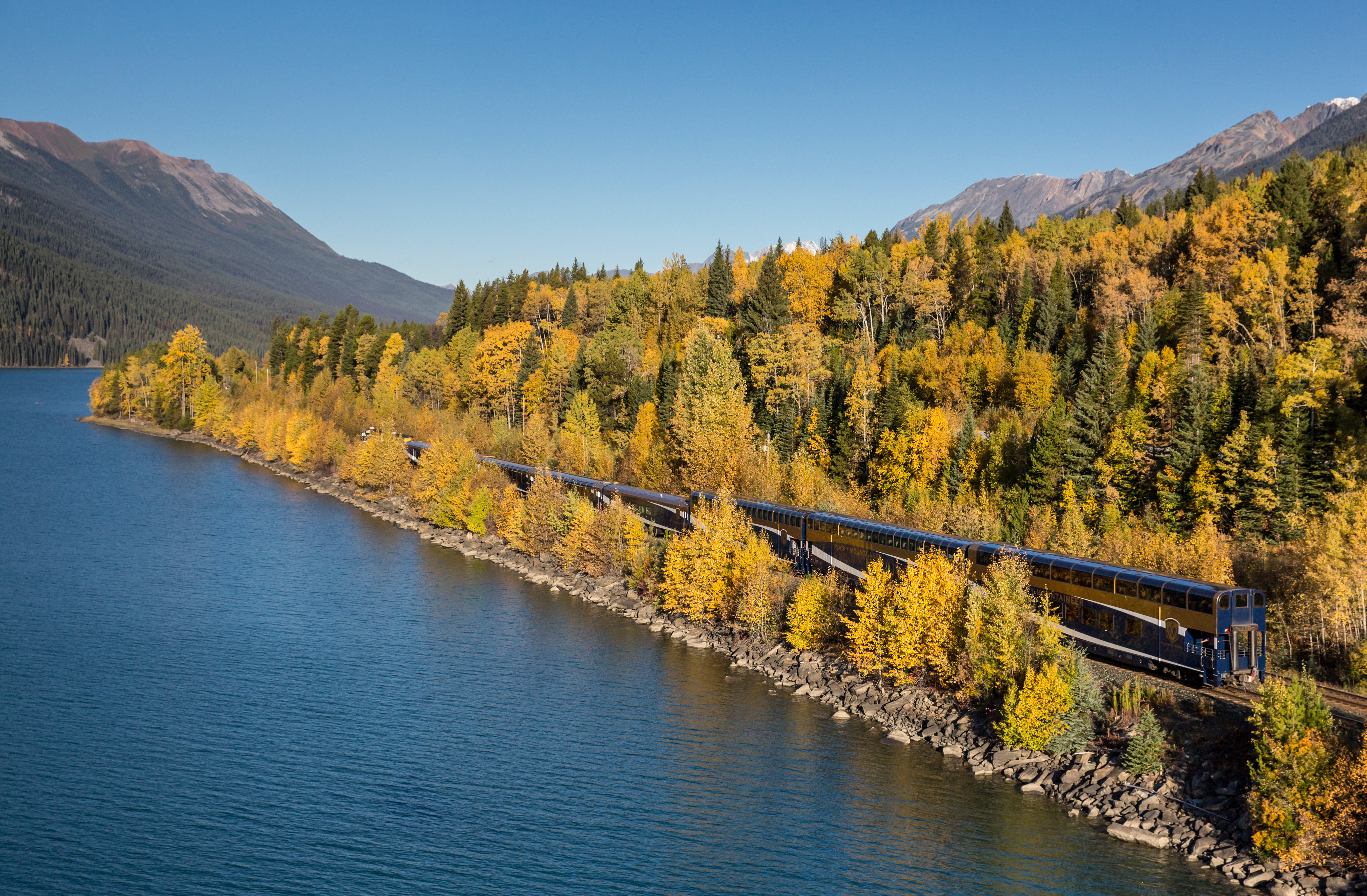 a train passes between mountains covered in trees